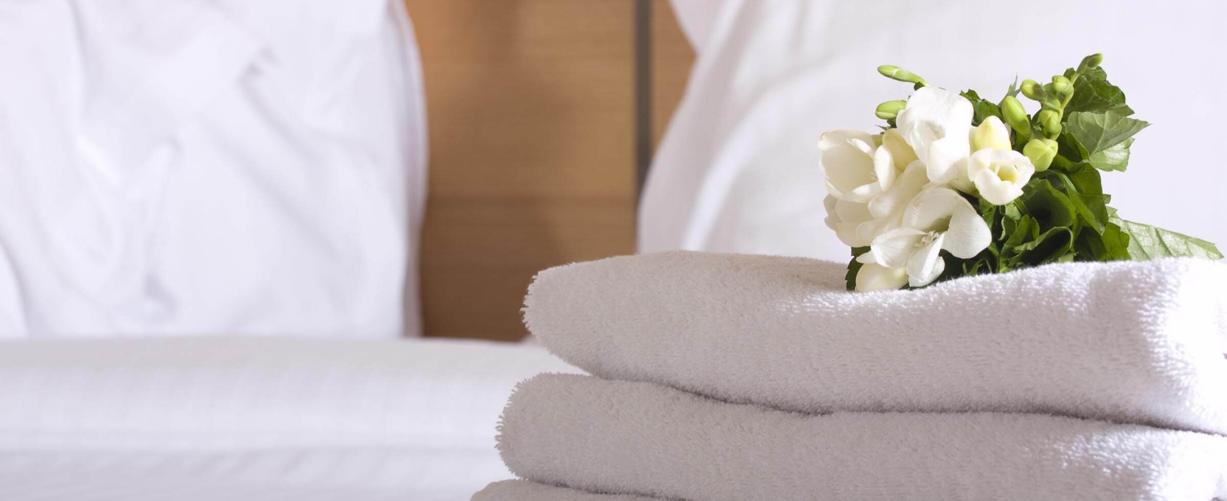toallas y flores en la cama del hotel